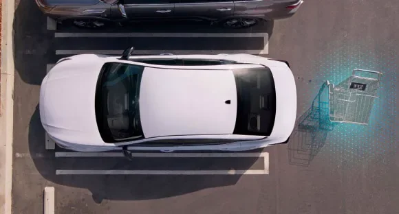 Top view of a white 2027 Nissan Altima in a parking lot with rear sensors detecting a shopping cart behind it at Mtn View Nissan of Bristol in Bristol TN
